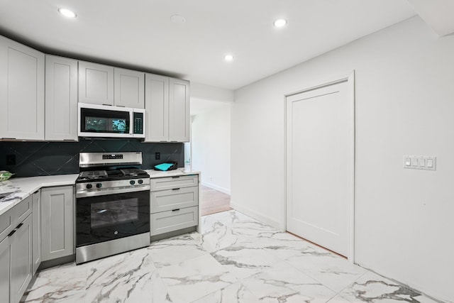 1 Whippoorwill Trl, Monroe, NY 10950 - kitchen with white microwave, gas range, recessed lighting, light marble finish flooring, and light countertops