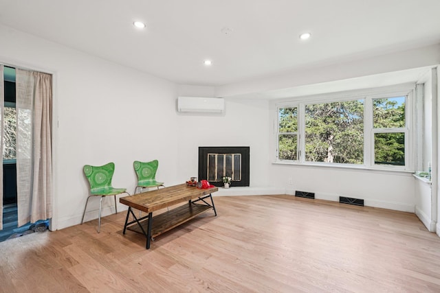 1 Whippoorwill Trl, Monroe, NY 10950 - living area with a glass covered fireplace, a wall mounted AC, light wood-type flooring, and recessed lighting