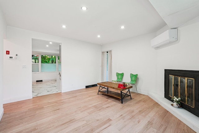 1 Whippoorwill Trl, Monroe, NY 10950 - living area featuring a wall mounted AC, recessed lighting, light wood finished floors, and a glass covered fireplace