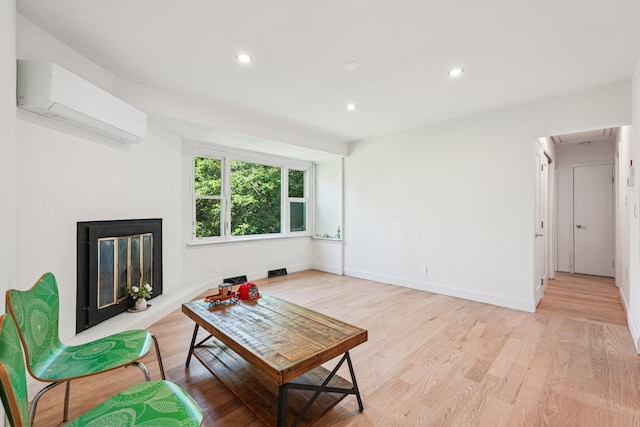 1 Whippoorwill Trl, Monroe, NY 10950 - living room featuring a wall unit AC, light wood-style flooring, recessed lighting, and a glass covered fireplace