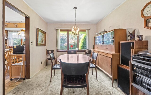 15 Lane Ave, Plainview, NY 11803 - dining space featuring a chandelier, plenty of natural light, light colored carpet, and ornamental molding
