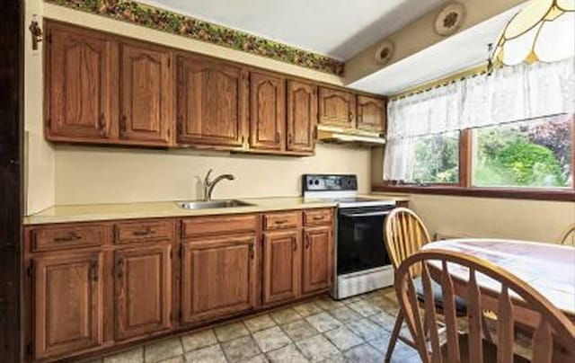 15 Lane Ave, Plainview, NY 11803 - kitchen featuring white range with electric cooktop, light countertops, under cabinet range hood, and brown cabinetry