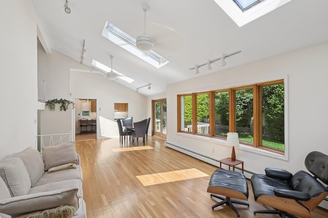 19 Evelyn Rd, Plainview, NY 11803 - living area with a skylight, track lighting, vaulted ceiling, light wood-style floors, and a baseboard radiator