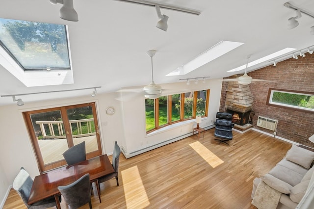 19 Evelyn Rd, Plainview, NY 11803 - living room with rail lighting, a skylight, a wall unit AC, brick wall, and baseboard heating