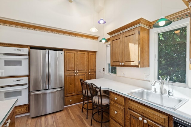 19 Evelyn Rd, Plainview, NY 11803 - kitchen with freestanding refrigerator, double oven, brown cabinetry, light countertops, and light wood-type flooring