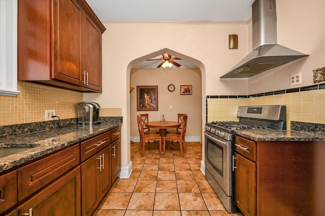 32-15 149th St, Flushing, NY 11354 - kitchen featuring wall chimney range hood, gas stove, arched walkways, decorative backsplash, and dark stone countertops