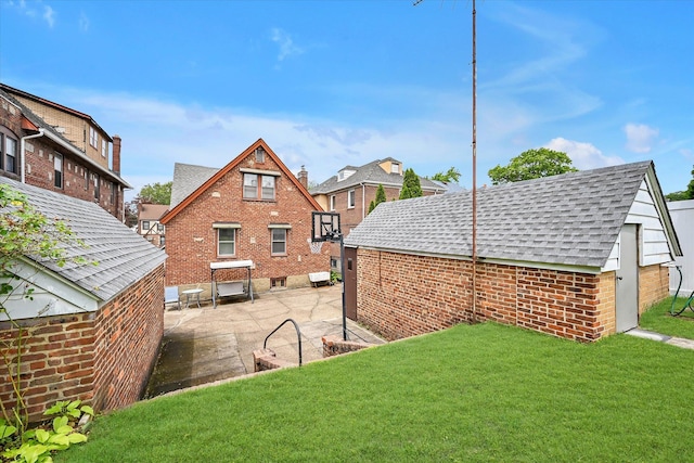 32-15 149th St, Flushing, NY 11354 - rear view of property featuring a shingled roof, a lawn, a patio, and brick siding