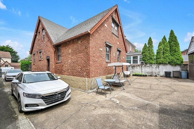 32-15 149th St, Flushing, NY 11354 - view of home's exterior featuring brick siding, a shingled roof, and a patio area