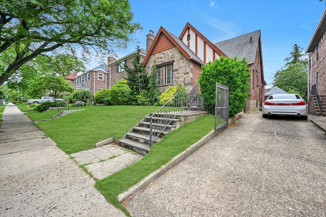 32-15 149th St, Flushing, NY 11354 - english style home with stone siding, a front lawn, a chimney, and brick siding