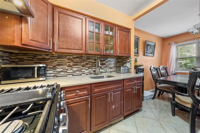 1157 E 102nd St, Brooklyn, NY 11236 - kitchen with stainless steel microwave, backsplash, ventilation hood, range with gas stovetop, and glass insert cabinets