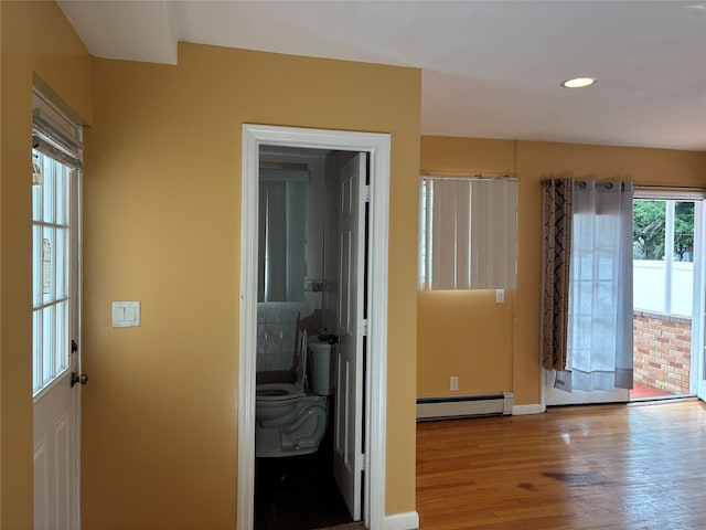 92 Norfeld Blvd, Elmont, NY 11003 - hallway with baseboard heating, wood finished floors, and recessed lighting