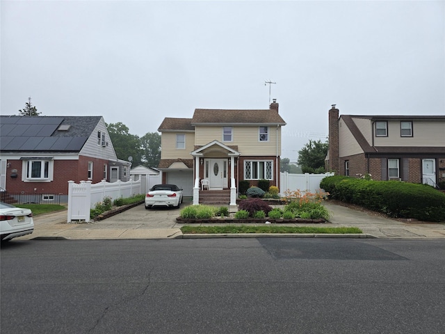 92 Norfeld Blvd, Elmont, NY 11003 - view of front facade featuring concrete driveway, a garage, and a chimney