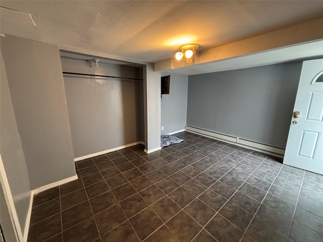 92 Norfeld Blvd, Elmont, NY 11003 - unfurnished bedroom featuring a baseboard radiator, dark tile patterned floors, and a closet