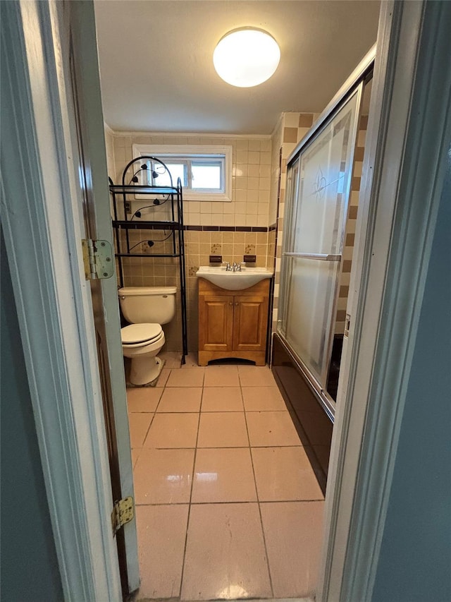 92 Norfeld Blvd, Elmont, NY 11003 - bathroom with tile patterned floors, tile walls, vanity, and shower / bath combination with glass door