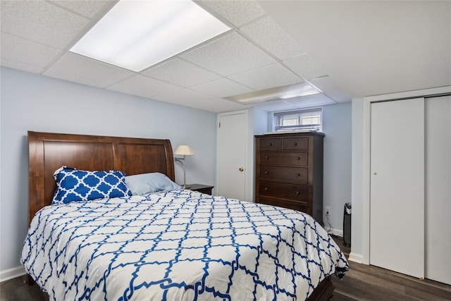 11 Robin Ln, Plainview, NY 11803 - bedroom with dark wood finished floors, a paneled ceiling, and a closet