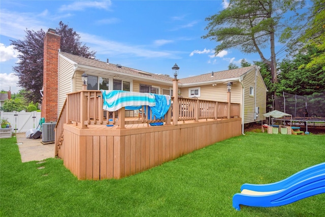 11 Robin Ln, Plainview, NY 11803 - back of house with a trampoline, a wooden deck, a chimney, and a gate