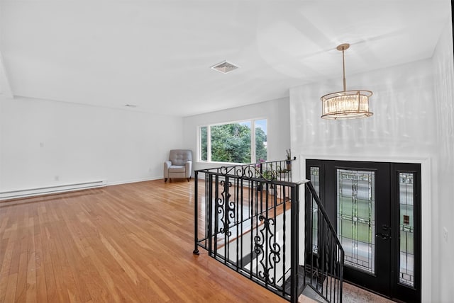 12 Valley Ln, Garrison, NY 10524 - entryway with baseboard heating, wood finished floors, and a chandelier