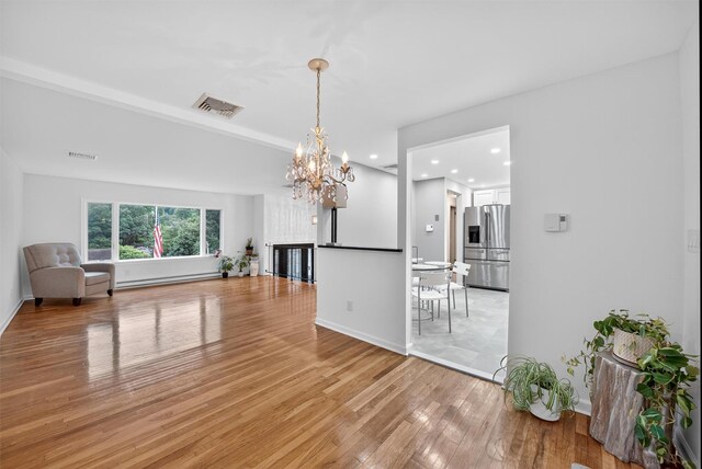 12 Valley Ln, Garrison, NY 10524 - unfurnished living room featuring light wood-style flooring, a chandelier, recessed lighting, and a baseboard heating unit