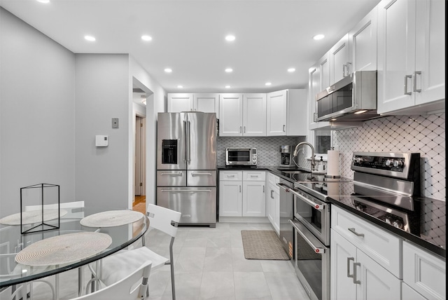 12 Valley Ln, Garrison, NY 10524 - kitchen with stainless steel appliances, dark countertops, backsplash, white cabinetry, and recessed lighting
