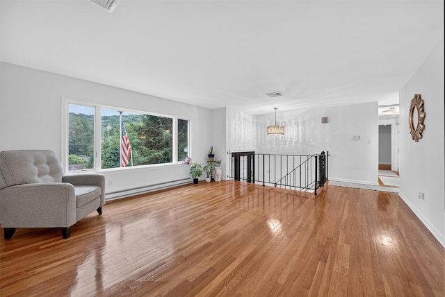 12 Valley Ln, Garrison, NY 10524 - living area featuring baseboard heating, an upstairs landing, wood finished floors, and a chandelier