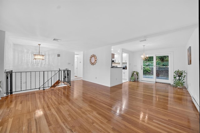 12 Valley Ln, Garrison, NY 10524 - unfurnished living room featuring a chandelier and light wood-type flooring
