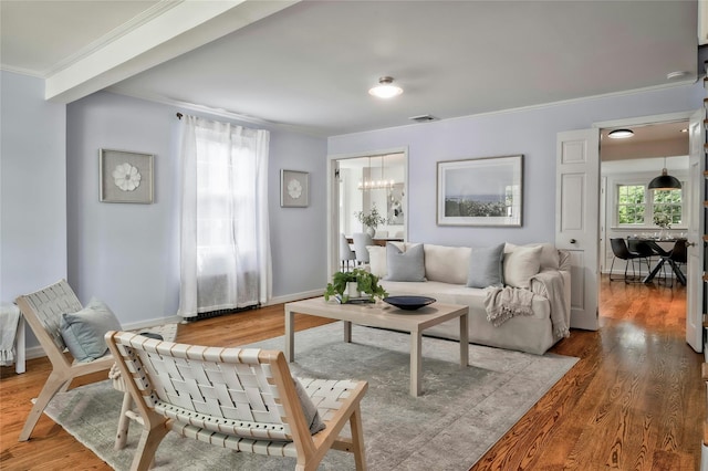 10 Cross St, Port Washington, NY 11050 - living room featuring crown molding, wood finished floors, and a chandelier