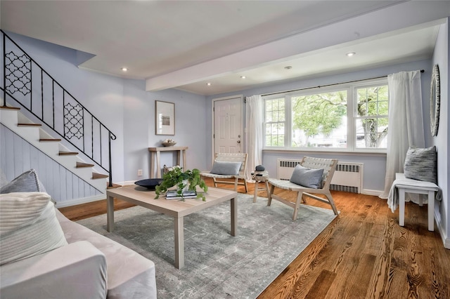 10 Cross St, Port Washington, NY 11050 - living area with radiator heating unit, wood finished floors, beamed ceiling, stairway, and recessed lighting