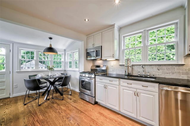 10 Cross St, Port Washington, NY 11050 - kitchen with stainless steel appliances, dark countertops, white cabinets, decorative backsplash, and recessed lighting