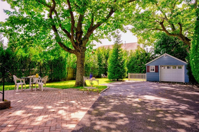 10 Cross St, Port Washington, NY 11050 - view of patio / terrace featuring a garage, an outbuilding, and asphalt driveway
