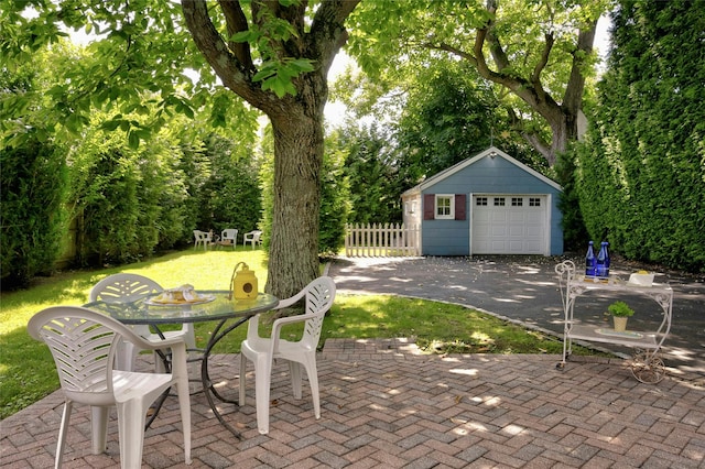 10 Cross St, Port Washington, NY 11050 - view of patio featuring an outdoor structure, a detached garage, driveway, and outdoor dining area