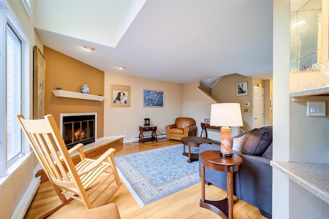 125 Fairways Cres, Carmel, NY 10512 - living room with light wood-style floors, a glass covered fireplace, a skylight, a baseboard radiator, and recessed lighting