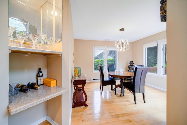 125 Fairways Cres, Carmel, NY 10512 - dining space featuring light wood finished floors, a dry bar, a baseboard heating unit, and a chandelier