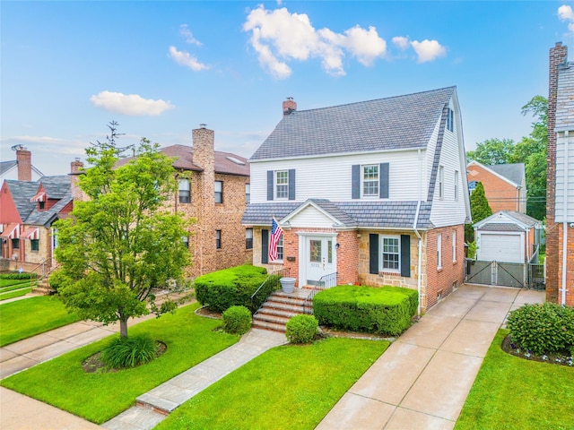 5023 213th St, Bayside, NY 11364 - view of front facade featuring a front lawn, an outdoor structure, a detached garage, brick siding, and a chimney