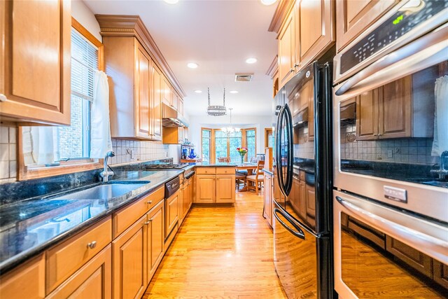5023 213th St, Bayside, NY 11364 - kitchen with appliances with stainless steel finishes, a peninsula, light wood-type flooring, under cabinet range hood, and decorative backsplash