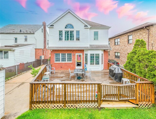 5023 213th St, Bayside, NY 11364 - back of house featuring brick siding, outdoor dining area, and a wooden deck