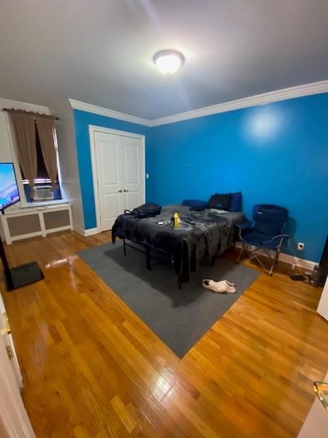 35-21 81st St Unit 1B, Jackson Heights, NY 11372 - bedroom featuring crown molding, wood finished floors, and a closet