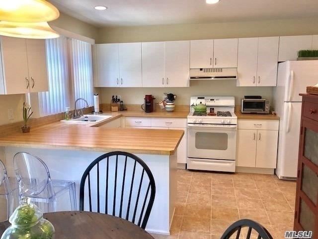 87 Marjorie Ct, Manhasset, NY 11030 - kitchen featuring white appliances, ventilation hood, light countertops, white cabinetry, and recessed lighting