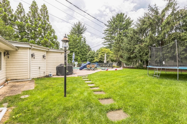 18 Sherwood Ln, Roslyn Heights, NY 11577 - view of grassy yard with a trampoline, a patio, and a pool