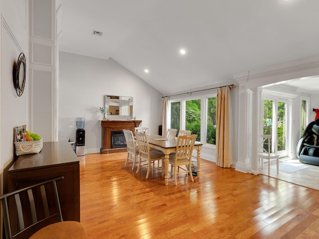 18 Sherwood Ln, Roslyn Heights, NY 11577 - dining space with decorative columns, a glass covered fireplace, light wood-type flooring, lofted ceiling, and recessed lighting