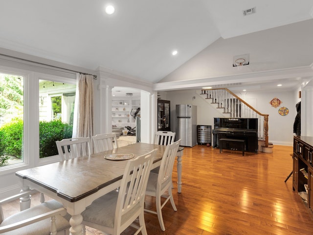 18 Sherwood Ln, Roslyn Heights, NY 11577 - dining room featuring decorative columns, vaulted ceiling, stairway, light wood-type flooring, and recessed lighting