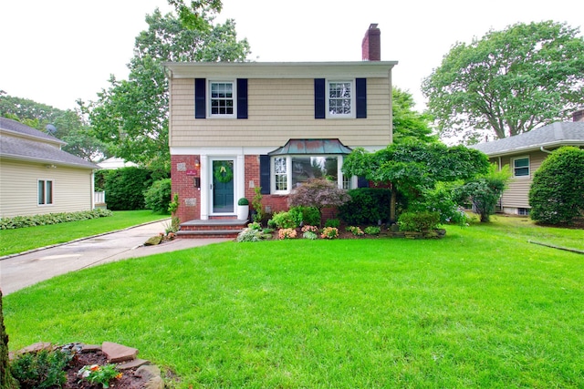 30 Prescott St, Garden City, NY 11530 - colonial home featuring a chimney, brick siding, and a front lawn