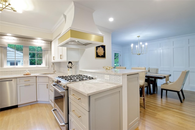 30 Prescott St, Garden City, NY 11530 - kitchen featuring stainless steel appliances, a chandelier, premium range hood, light wood-type flooring, and crown molding