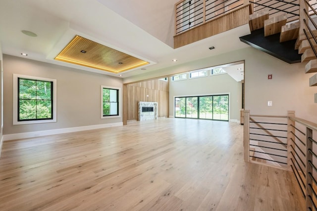 352 Cold Spring Rd, Syosset, NY 11791 - unfurnished living room featuring light wood finished floors, a fireplace, a raised ceiling, a towering ceiling, and recessed lighting