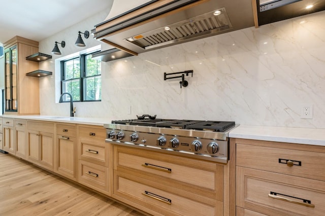 352 Cold Spring Rd, Syosset, NY 11791 - kitchen with custom range hood, stainless steel gas cooktop, backsplash, light brown cabinetry, and light wood finished floors