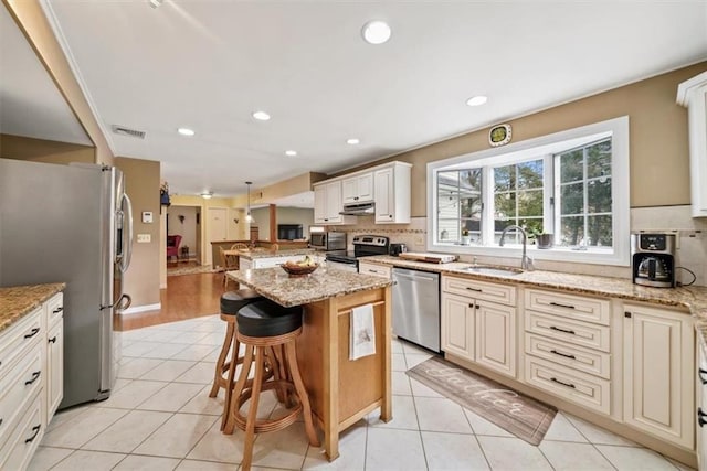 1 Cindy Ln, Highland Mills, NY 10930 - kitchen with appliances with stainless steel finishes, backsplash, under cabinet range hood, a kitchen bar, and a center island