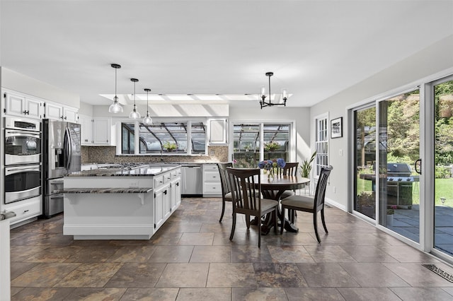 353 Split Rock Rd, Syosset, NY 11791 - kitchen featuring appliances with stainless steel finishes, backsplash, healthy amount of natural light, and white cabinets