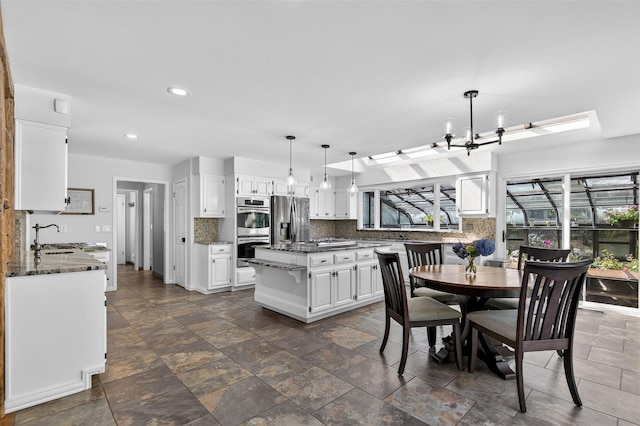 353 Split Rock Rd, Syosset, NY 11791 - dining area featuring recessed lighting, dark stone finish flooring, and a chandelier