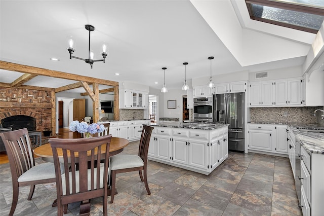 353 Split Rock Rd, Syosset, NY 11791 - kitchen with stainless steel refrigerator with ice dispenser, decorative backsplash, stone counters, a chandelier, and a kitchen island