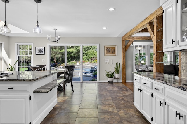 353 Split Rock Rd, Syosset, NY 11791 - kitchen featuring a chandelier, dark stone countertops, recessed lighting, pendant lighting, and white cabinetry
