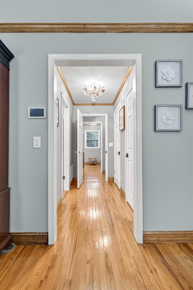 353 Split Rock Rd, Syosset, NY 11791 - hallway featuring crown molding, light wood-style flooring, and a chandelier